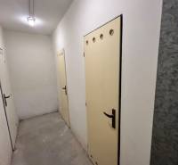 Predaj 3 izb. bytu s balkónom v NZ - Chodba s viacerými dverami v priestore 3-izbového bytu, svetlé steny, betónová podlaha.