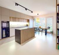 Novozariadený rodinný dom s veľkými spálňami i šatníkom pri Trenčíne   - Otvorná kuchyňa s jedálenským stolom a knihovničkou v rodinnom dome.