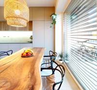 Novozariadený rodinný dom s veľkými spálňami i šatníkom pri Trenčíne   - Kuchyňa v rodinnom dome s masívnym stolom a závesným svietidlom.