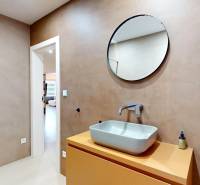 Novozariadený rodinný dom s veľkými spálňami i šatníkom pri Trenčíne   - Kúpeľňa v rodinnom dome s umývadlom, okrúhlym zrkadlom a sprchovým kútom.