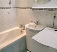 2 izbový byt na Severe - Kúpeľňa 2-izbového bytu s vaňou, umývadlom a práčkou.