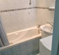 2 izbový byt na Severe - Kúpeľňa v 2-izbovom byte s vaňou a svetlými obkladmi.