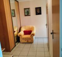 2 izbový byt na Severe - Kreslo pri vstupných dverách s dlaždicovou podlahou v 2-izbovom byte, zrkadlová skriňa.