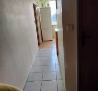 2 izbový byt na Severe - Chodba s chladničkou v 2-izbovom byte, dlažba na podlahe, svetlé steny.