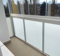 2 izbový byt na Severe - Zasklený balkón v 2-izbovom byte s výhľadom na stromy a hory.