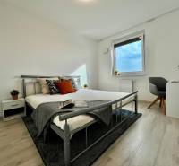 KOMPLETNE ZARIADENÝ SVETLÝ 2-IZB. BYT, NOVOSTAVBA NUPPU, HRANIČNÁ UL. - Spálňa v 2-izbovom byte s podlahou s dreveným dekorom a kovovou posteľou.