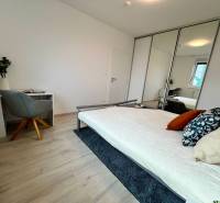 KOMPLETNE ZARIADENÝ SVETLÝ 2-IZB. BYT, NOVOSTAVBA NUPPU, HRANIČNÁ UL. - Spálňa v 2-izbovom byte s posteľou, pracovným stolom a zrkadlovou skriňou.