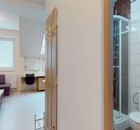 Na prenájom zariadené kancelárie v centre mesta Holíč - Kancelárie s rohovou sedačkou, stolom, sprchou a dreveným dekorom na stene.