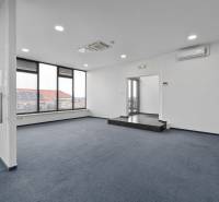 Prenájom kancelárií s TERASOU a výborným parkovaním, 150 m2, Ružinov - Kancelárie s presklenými dverami a kobercom, s výhľadom na strechy a slnečné panely.