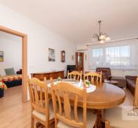 Nové v ponuke | 3-izbový byt 91 m² | 2× balkón | parkovanie | RUSTICA  - Jedálenský stôl s drevenými stoličkami v 3-izbovom byte, vedľa obývacia izba.