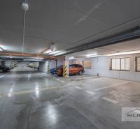 Nové v ponuke | 3-izbový byt 91 m² | 2× balkón | parkovanie | RUSTICA  - Podzemné parkovisko s označenými parkovacími státiami a zaparkovanými autami a motorkami.