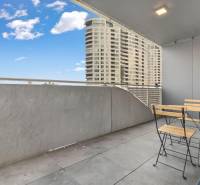 - PREDAJ - APARTMÁN - 38 m2 + 14 m2 LOGGIA - TEHELNÉ POLE - Balkón s moderným nábytkom, výhľad na vysoké budovy v Bratislave - Novom Meste.