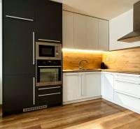 Vkusne zariadený 2i byt na sídlisku WEST,  Galanta - Kuchyňa 2-izbového bytu s podlahou s dreveným dekorom a vstavanými spotrebičmi.