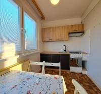 Prenájom 2-izbového bytu v Poprade na Dostojevského ul. - Kuchyňa v 2-izbovom byte s podlahou s dreveným dekorom a jedálenským stolom.