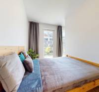 BA/PETRŽALKA-Prenájom 1i bytu s klimatizáciou a balkónom - Slnečnice - Spálňa s drevenou posteľou a posteľnou bielizňou v 1-izbovom byte, veľké okno, záclony.