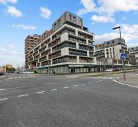 BA/PETRŽALKA-Prenájom 1i bytu s klimatizáciou a balkónom - Slnečnice - Križovatka s modernými budovami v Bratislave - Petržalke, obloha s oblakmi.