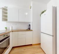 BA/PETRŽALKA-Prenájom 1i bytu s klimatizáciou a balkónom - Slnečnice - Kuchyňa v 1-izbovom byte s bielou linkou, spotrebičmi a svetlým dreveným podlahovým obkladom.