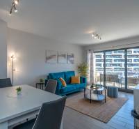 Luxusný byt  Alicante, 112m2, bazén, 2 garáže, posilňovňa - Obývacia izba v 2-izbovom byte s podlahou s dreveným dekorom a posedením.