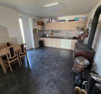 Zabehnutá novostavba: Komfort domu, pokoj vidieka a na skok do BB a ZV - Kuchyňa v rodinnom dome s kuchynskou linkou, jedálenským stolom a sporákom.