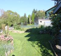 Zabehnutá novostavba: Komfort domu, pokoj vidieka a na skok do BB a ZV - Záhrada pri rodinnom dome na Lipovej ulici v Lukavici, obklopená zeleňou a kvetmi.