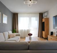 Rezervované -  3i byt v Nemšovej s loggiou po rekonštrukcii - 74m²  - Obývacia izba v 3-izbovom byte s podlahou s dreveným dekorom a veľkým televízorom.