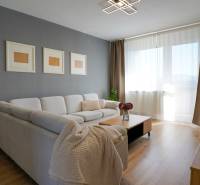 Rezervované -  3i byt v Nemšovej s loggiou po rekonštrukcii - 74m²  - Obývacia izba v 3-izbovom byte so sedačkou a podlahou s dreveným dekorom.