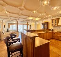 I PRENÁJOM - Priestranný 4 izbový byt na Zámockej ulici, BA - Kuchyňa v 4-izbovom byte s podlahou s dreveným dekorom a barovými stoličkami.