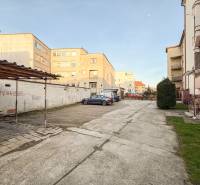 2i byt 43m2 + parkovacie miesto, Hodžova ul., Trenčín - Parkovisko pri 2-izbových bytoch na Hodžovej ulici v Trenčíne s autami a zeleňou.