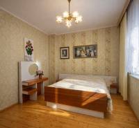 Rodinný dom · Terchová – Biely Potok - Spálňa v rodinnom dome s podlahou s dreveným dekorom a kvetinovými tapetami.