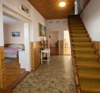 Rodinný dom · Terchová – Biely Potok - Chodba rodinného domu s kobercom, schodmi a posteľou v ďalšej miestnosti.
