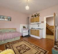 Rodinný dom · Terchová – Biely Potok - Izba s kuchynskou linkou, pohovkou, sporákom a podlahou s dreveným dekorom v rodinnom dome.