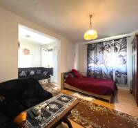 EXKLUZÍVNY PREDAJ - 1 izbový byt, Vodárenská ulica Galanta - Útulný 1-izbový byt s podlahou s dreveným dekorom, posteľou a pohovkou s kvetovaným vzorom.