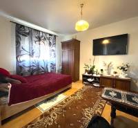 EXKLUZÍVNY PREDAJ - 1 izbový byt, Vodárenská ulica Galanta - Izba jedného bytu s posteľou, televízorom a podlahou s dreveným dekorom.