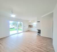 | 4 izbový rodinný dom s krbom a terasov | Slnečná | Ružindol - Obývacia izba v Rodinnom dome s podlahou s dreveným dekorom a priehľadmi do záhrady.