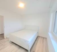 | 4 izbový rodinný dom s krbom a terasov | Slnečná | Ružindol - Spálňa v rodinnom dome s posteľou, bielymi stenami a podlahou s dreveným dekorom.