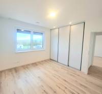 | 4 izbový rodinný dom s krbom a terasov | Slnečná | Ružindol - Miestnosť v rodinnom dome s podlahou s dreveným dekorom, šatníkovou skriňou a oknom.