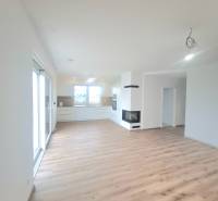 | 4 izbový rodinný dom s krbom a terasov | Slnečná | Ružindol - Obývacia izba v rodinnom dome s kuchyňou, krbom a podlahou s dreveným dekorom.