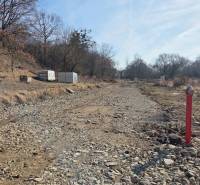 NA PREDAJ STAVEBNÝ POZEMOK V DOSAHU MHD PREŠOV - HANISKA - Pozemky - bývanie v Haniske, kamenistá cesta medzi stromami a kontajner.