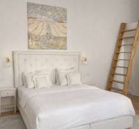 NA PRENÁJOM,Nadštandardný 3-izbový tehlový byt s parkingom,Mlynská ul. - Svetlá spálňa s posteľou, obrazom na stene, nočným stolíkom a podlahou s dreveným dekorom.