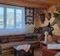 Predaj ,drevená chatka v obci Kráľovce Krnišov - Interiér chaty s trofejami, dreveným obložením a podlahou s dreveným dekorom.