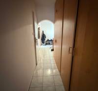 Predaj 3.izbového bytu v Ružinove v obkolesené borovicového lesíka - Úzka chodba s dlažbou a vstavanými skriňami vedúca do obývacej časti 3-izbového bytu.