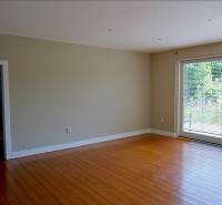 Rodinný dom s veľkou záhradou - Ružinov  - Interiér v rodinnom dome s podlahou s dreveným dekorom a veľkými oknami.