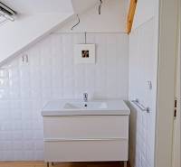 Rodinný dom s veľkou záhradou - Ružinov  - Kúpeľňa rodinného domu s umývadlom a podlahou s dreveným dekorom.