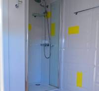 Rodinný dom s veľkou záhradou - Ružinov  - Sprchovací kút s viacfarebnou stenou a podlahou s dreveným dekorom v rodinnom dome.