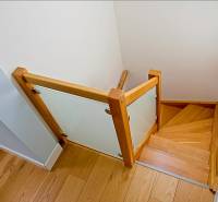 Rodinný dom s veľkou záhradou - Ružinov  - Drevené schodisko so skleneným zábradlím v rodinnom dome s podlahou s dreveným dekorom.