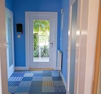 Rodinný dom s veľkou záhradou - Ružinov  - Chodba v rodinnom dome s modrými stenami a mozaikovou podlahou.