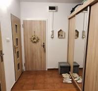 PREDAJ: 4 izbový byt s balkónom, 82 m2 - KOMÁRNO - Chodba v 4-izbovom byte s vešiakmi a zrkadlovou skriňou na podlahe s dreveným dekorom.