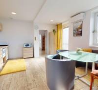 DOBROHOŠŤ- Prenájom  3i zariadeného bytu s predzáhradkou a parkingom - Kuchyňa v 3-izbovom byte s podlahou s dreveným dekorom, svetlými skrinkami a jedálenským stolom.