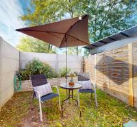 DOBROHOŠŤ- Prenájom  3i zariadeného bytu s predzáhradkou a parkingom - Záhrada 3-izbového bytu v Dobrohošti so stolom, stoličkami a slnečníkom.