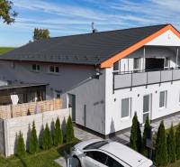 DOBROHOŠŤ- Prenájom  3i zariadeného bytu s predzáhradkou a parkingom - Exteriér 3-izbového bytu v Dobrohošti obklopujú ihličnany a moderné plotové prvky.